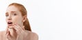 redheaded woman shows fingers on acne on her face. Royalty Free Stock Photo