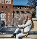 Tourist woman in front of Sforza Castle sitting near fountain Royalty Free Stock Photo