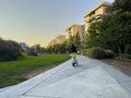 Redmond, WA USA - circa September 2022: Wide angle view of people riding rental scooters at sunset in downtown Redmond