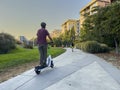 Redmond, WA USA - circa September 2022: Wide angle view of people riding rental scooters at sunset in downtown Redmond