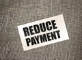 Reduce payment text on card on burlap canvas. business concept