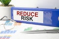 Reduce Risk Concept words on the blue folder and charts Royalty Free Stock Photo