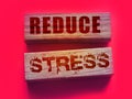 Reduce Stress text on wooden blocks on vivid pink. Calm relax health concept