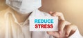 Reduce Stress words on a Card in Hands of Doctor. Healthcare relax stressfull job concept