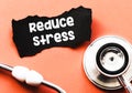Reduce stress words on a small piece of paper next to a stethoscope