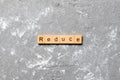 Reduce word written on wood block. reduce text on cement table for your desing, concept