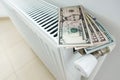 Reduce your energy bill for house heating with us dollars banknotes on white radiator