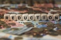 Reduction - cube with letters, money sector terms - sign with wooden cubes Royalty Free Stock Photo