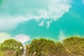 Reed along the edge of quarry lake in sunlight. sky and clouds reflect in water. aerial view Royalty Free Stock Photo