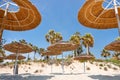 Reed beach umbrellas, sunshades against blue sky on the beach. Bamboo parasols, straw umbrellas on on white sandy Royalty Free Stock Photo