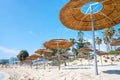 Reed beach umbrellas, sunshades against blue sky on the beach. Bamboo parasols, straw umbrellas on on white sandy Royalty Free Stock Photo