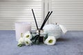 Reed diffuser, scented candle, box and eustoma flowers on gray marble table Royalty Free Stock Photo