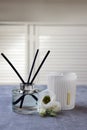 Reed diffuser, scented candle and eustoma flowers on gray marble table