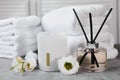 Reed diffuser, scented candle, flowers and folded towels on gray marble table Royalty Free Stock Photo