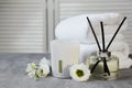 Reed diffuser, scented candle, flowers and folded towels on gray marble table Royalty Free Stock Photo