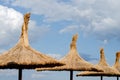 Reed umbrella roof against blue cloudy  sky  . Royalty Free Stock Photo