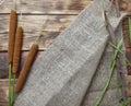 Reeds,  bulrush with sack fabric, tree branch on wooden background. Royalty Free Stock Photo