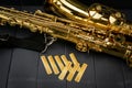 Reeds of mouth piece of a saxophone with a tenor saxophone on gray wooden background Royalty Free Stock Photo