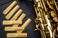 Reeds of the mouthpiece of a sax next to the golden and shiny instrument Royalty Free Stock Photo