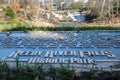 Reedy River Falls Historic Park sign with waterfall in the distance, Greenville, South Carolina Royalty Free Stock Photo