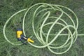 Reel of hose pipe and spraying head on grass. Royalty Free Stock Photo