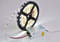 Reel of luminous LED strip light connected to voltage transformer. Royalty Free Stock Photo