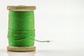 Reel or spool of green sewing thread on white. Shallow Royalty Free Stock Photo