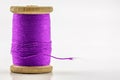 Reel or spool of violet sewing thread on white. Shallow Royalty Free Stock Photo