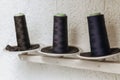 Reels with black threads for a sewing machine on a stand in atelier Royalty Free Stock Photo