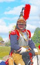 Reenactor dressed as Napoleonic war French soldier rides a horse.