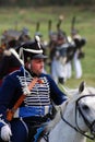 Reenactor dressed as Napoleonic war Russian soldier rides a horse.