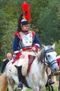 Reenactor dressed as Napoleonic war soldier rides a horse.