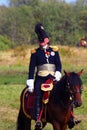 Reenactor dressed as Napoleonic war soldier rides a horse.