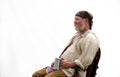 Reenactor listening to stories with a mug