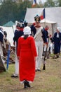 Reenactor man greets reenactor woman in red dress Royalty Free Stock Photo