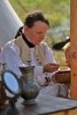 Reenactor woman feeds a child at Borodino battle historical reenactment in Russia