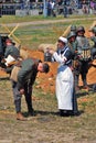 A reenactor woman (nurse) pours water on the head of a soldier