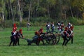 Reenactors dressed as Napoleonic war soldiers carry a cannon