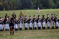 Reenactors dressed as Napoleonic war soldiers march on the battle field Royalty Free Stock Photo