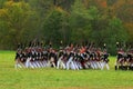 Reenactors dressed as Napoleonic war soldiers march on the battle field Royalty Free Stock Photo