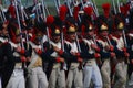 Reenactors dressed as Napoleonic war soldiers march holding guns