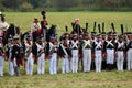 Reenactors dressed as Napoleonic war soldiers stand holding guns