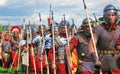 Reenactors dressed as soliders march holding spears