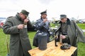 Reenactors dressed in uniforms of German officers of World War II drinking vodka on a lawn