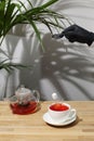 Ref fruit tea on wooden table. sugar cube falling in cup. splash of tea. tea pot with fruit tea Royalty Free Stock Photo