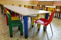 Refectory with small tables and colored chairs in the nursery sc Royalty Free Stock Photo