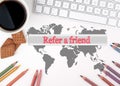 Refer a friend. White office desk with a cup of coffee, biscuits