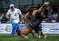 A referee looks on as a wrestler is flung to the ground by his opponent at the Kemer Turkish Oil Wrestling Festival in Turkey.