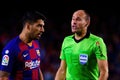 The referee Mateu Lahoz (R) disusses with Luis Suarez (L)