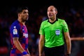 The referee Mateu Lahoz (R) disusses with Luis Suarez (L)